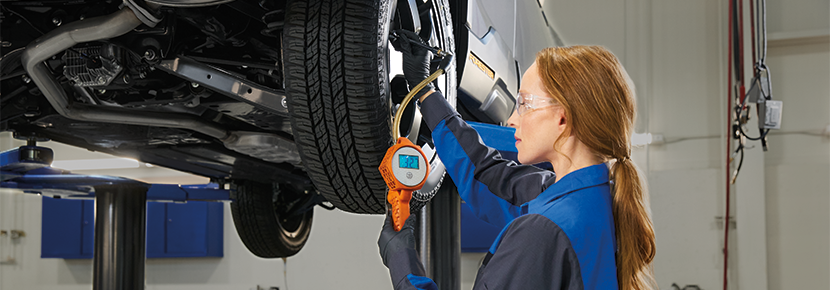 A Subaru technician checking tire pressure. | Salina Subaru in Salina KS