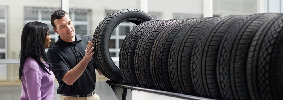 Subaru service representative showing customer a tire. | Salina Subaru in Salina KS
